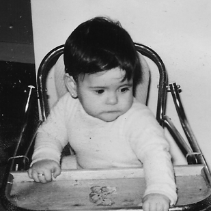 Baby sitting in vintage high chair
